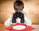 child looks at a plate throught a binoculars