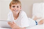 Boy using a tablet computer in a bedroom