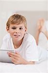 Portrait of a boy using a tablet computer in a bedroom