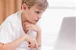 Young boy using a notebook in a bedroom