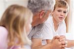 Father having a discussion with his children in a bedroom