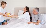 Boy serving breakfast to his parents in their bedroom