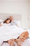 Portrait of a couple sleeping with the camera focus on their feet