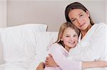 Mother and her daughter hugging in a bedroom
