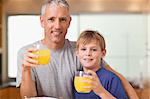 Young boy and his father having breakfast in a kitchen