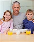 Portrait of a father posing with his children in the morning in a kitchen