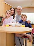 Portrait of a smiling family having breakfast in their kitchen