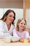 Portrait of a beautiful mother and her daughter having breakfast in a kitchen