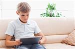 Cute boy using tablet computer in a living room