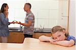 Sad girl hearing her parents fitting in a kitchen