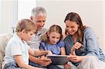 Happy family using a tablet computer in a living room