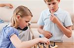 Children playing chess in a living room