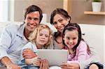 Charming family using a tablet computer in a living room