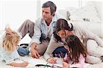 Family drawing together in a living room