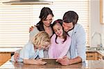 Family using a tablet computer together in a kitchen