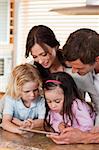 Portrait of a happy family using a tablet computer together in a kitchen