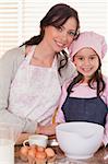 Portrait of a mother and her daughter baking in a kitchen