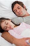 Portrait of a calm father sleeping with his daughter in a bedroom