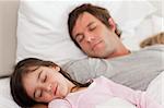 Calm father sleeping with his daughter in a bedroom