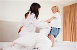 Playful family having pillow fight in a bedroom