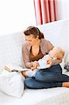 Young mom resting while baby sleep by having tea and reading book