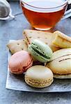 traditional french macarons with tea set on the background