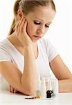 Young woman having flu takes pills on a white background