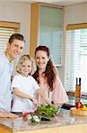 Young family preparing salad together