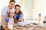 Family together with baking ingredients behind the kitchen counter