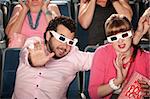 Scared Caucasian couple with 3D glasses in theater