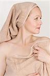 Adult beautiful woman after bath with a towel on her head. Over white. Not isolated.
