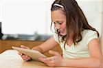 Girl at the kitchen table looking at tablet