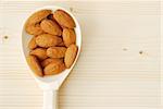 Almonds in the wooden spoon on the table