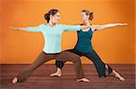 Two Caucasian women practicing yoga stretch their legs