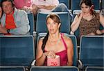 Horrified people watch movie in theater