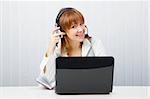 girl in headphones with a microphone and a laptop