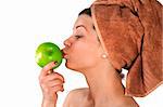 Beautiful young woman after bath with a towel on her head and an apple in her hand. Over white. Not isolated.