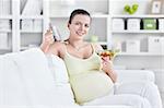A pregnant young woman eating salad