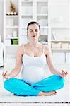 A pregnant young woman in lotus position