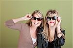 Smiling Caucasian mom and daughter look through sunglasses
