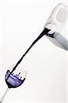 Pouring Purple Liquid from Jug into Wine Glass