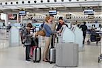 Mitarbeiter helfen Familie Check-In am Flughafen