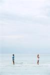 Couple standing apart in sea with backs turned toward each other