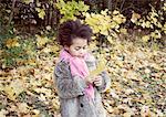 Little girl holding autumn leaf, portrait