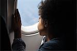 Garçon regardant fenêtre avion