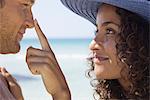 Couple at the beach, woman touching man's nose