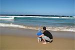 Père et son bébé à la plage, à la recherche en mer