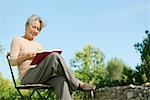 Senior woman reading book outdoors
