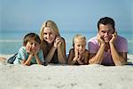 Famille couché sur le sable à la plage, portrait