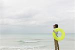 Jeune homme transportant l'anneau de natation, accès à distance